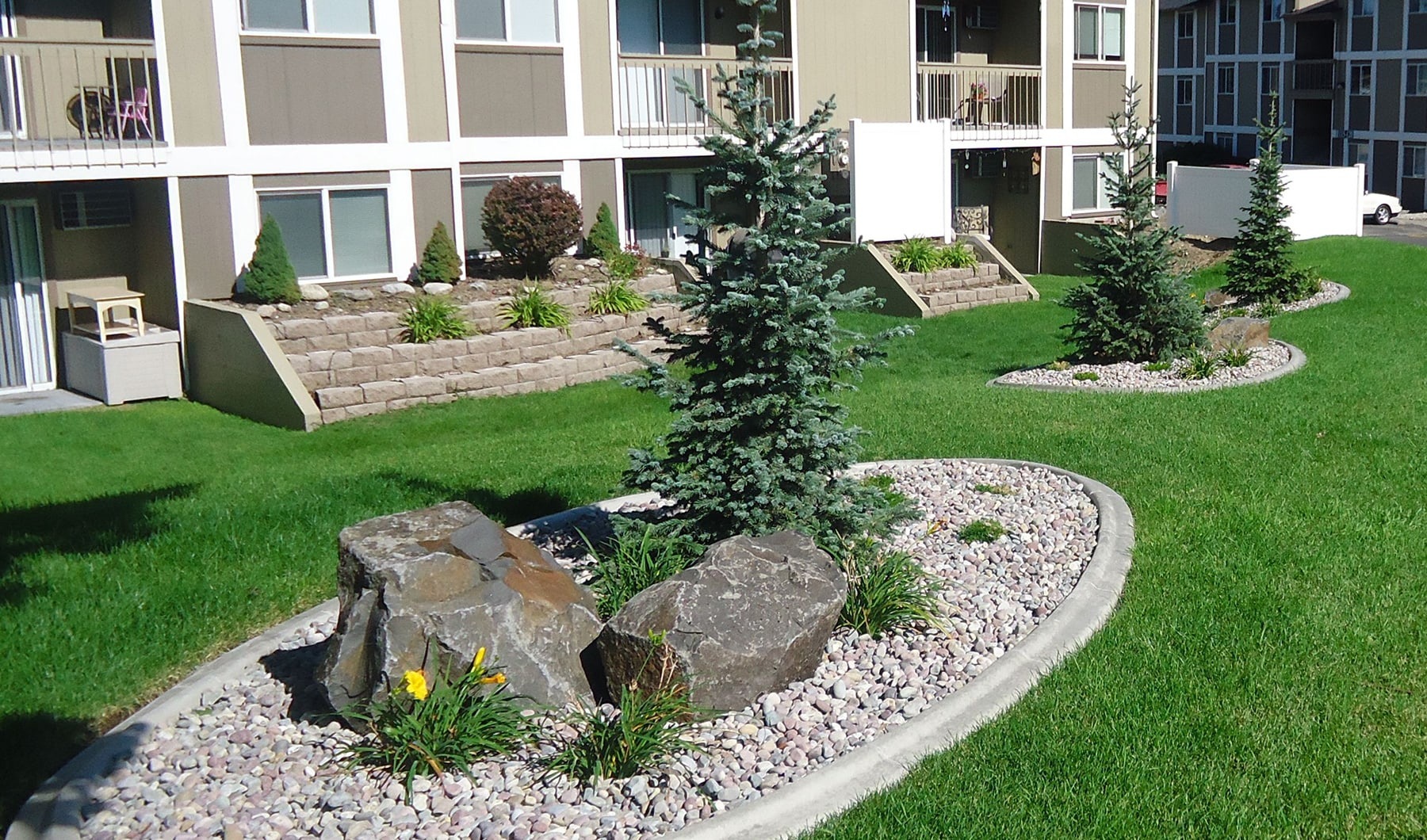 landscaping and green grass outside of apartment homes